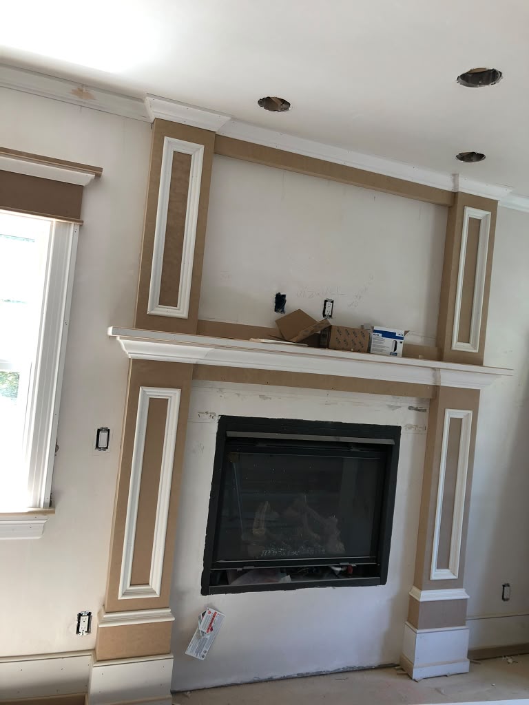 Custom fireplace surround with mantel and paneled trim
