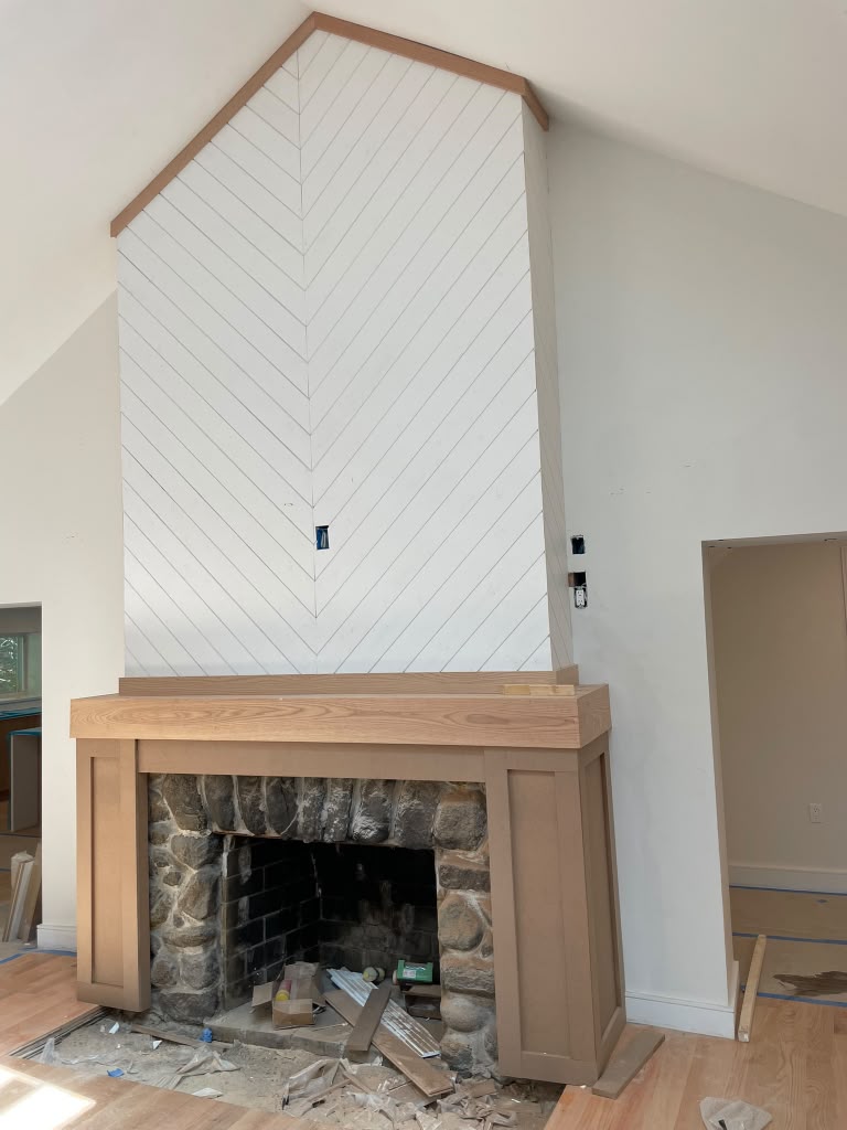 Remodeled fireplace with stone hearth, wood mantel and chevron paneled chimney