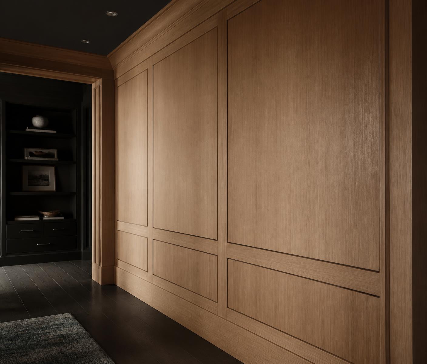 Custom white oak wall paneling and built-in millwork showing precise finish carpentry detail